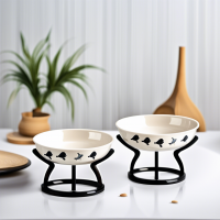 AA set of ceramic food bowls on stands, 2 bowls included: 1 with a paw pattern, 2 with a fish pattern. There is an individual black stand for each of the bowls. Use offers: profitable, easy to wash, safe materials, durable materials